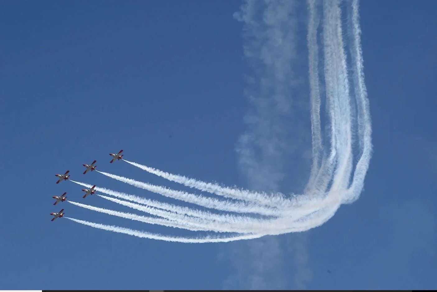 Four jets flying in formation with a trail of smoke.